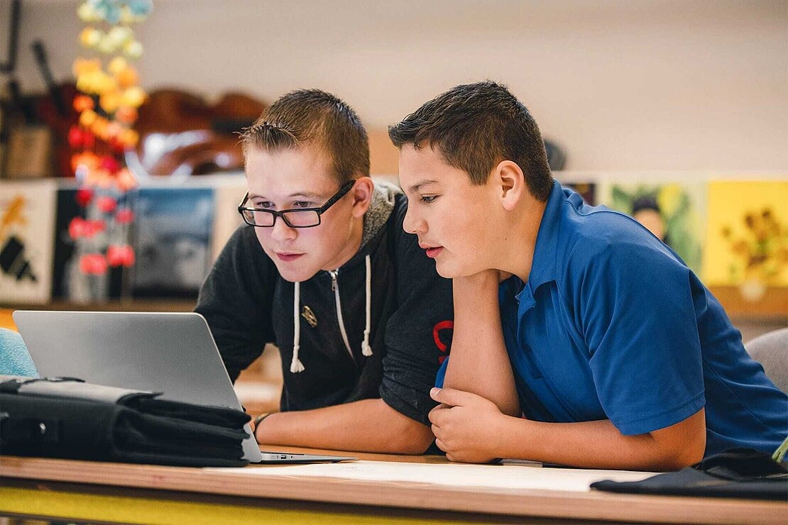 Referat Schule Fake News Desinformation Zwei Jungen recherchieren an Laptop