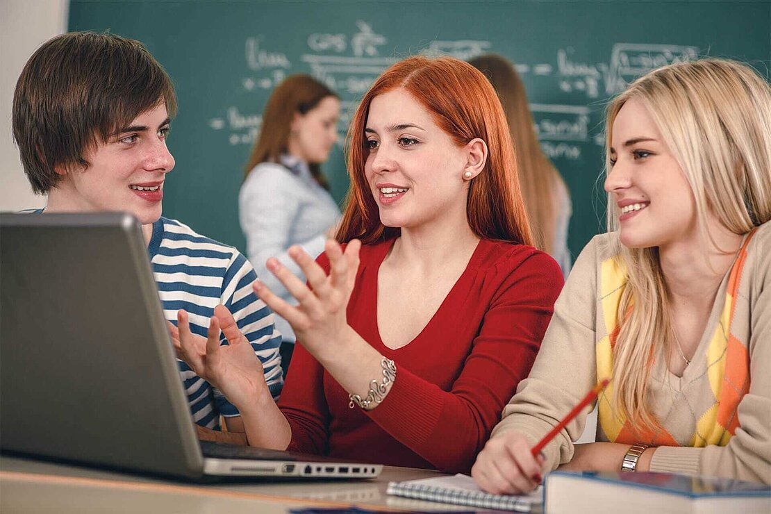 Net-Piloten Schulprojekt Medienkompetenz Drei Jugendliche im Klassenzimmer an Laptop