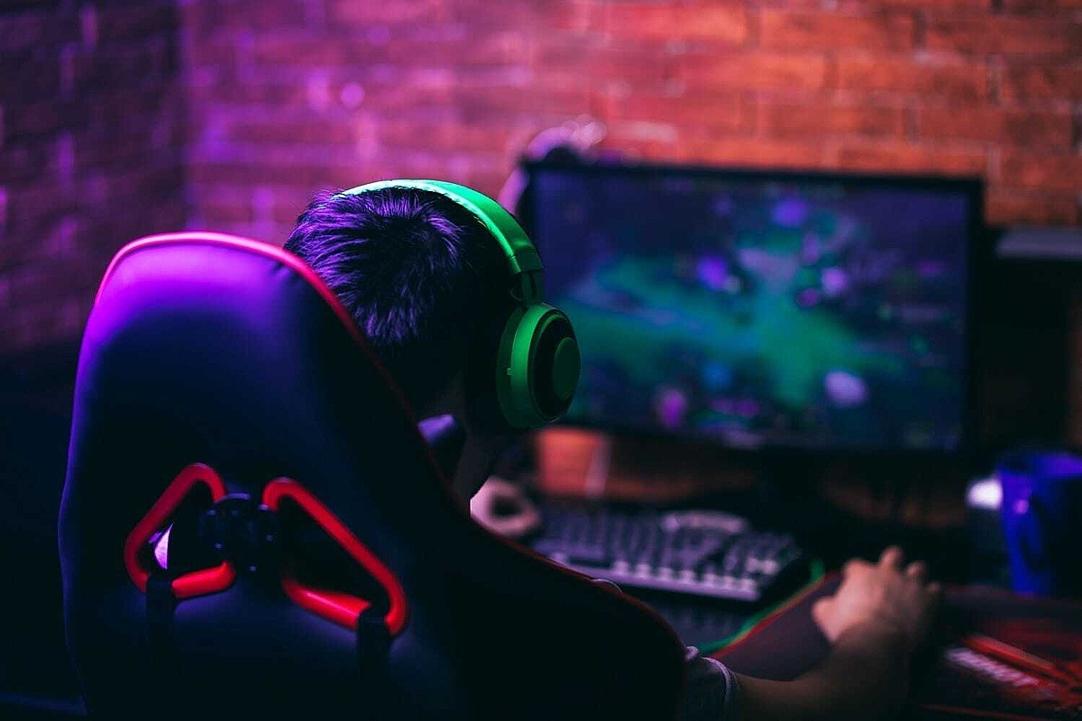 Gamer mit Headset spielt am PC 