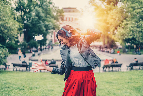 Jugendliche tanzt im Park zur Musik.