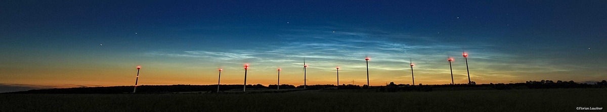 Panorama-Aufnahme eines Horizonts mit Windkrafträdern bei Sonnenaufgang