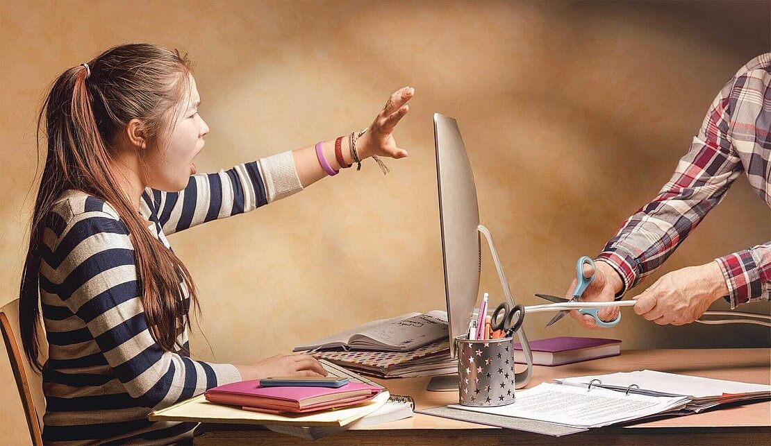 Immer cool bleiben – Weniger Stress im Netz Vater schneidet das Computerkabel durch, während das Mädchen vor dem Computer protestiert.